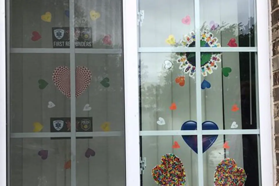 A glass door with paper hearts and “First Responders” signs taped to the interior window panels.